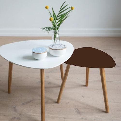 To små borde med træben, hvidt og brunt bord på trægulv.