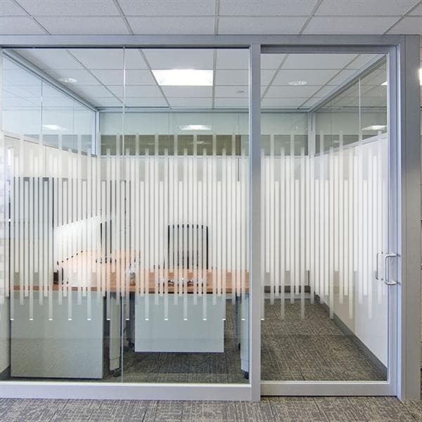 Glasvæg med sandblæst design og lodrette linjer. Halvgennemsigtig, perfekt til kontorskillevægge.