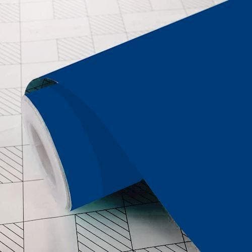 Rulle af blå folie med glat overflade på grid-mønstret baggrund.